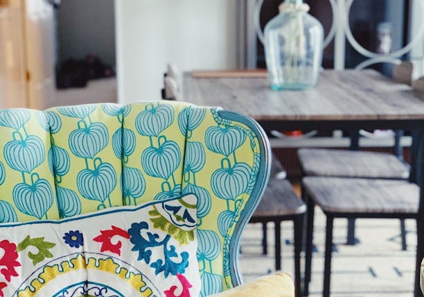 a table with chairs and a vase with flowers on it