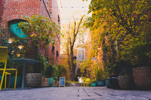 a brick building with trees and chairs