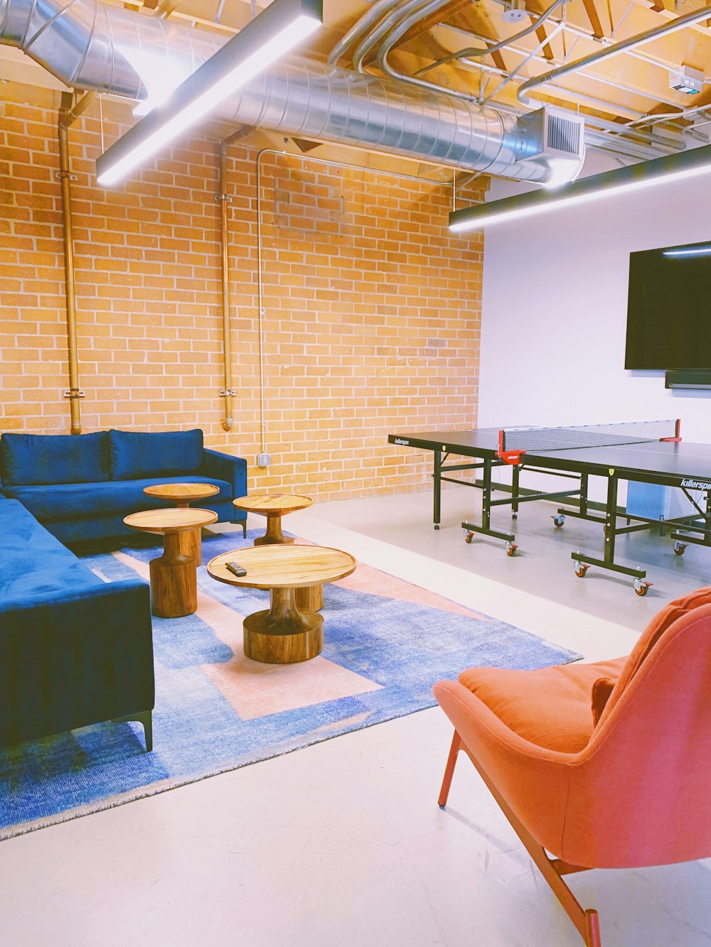 a room with blue couches and a brick wall