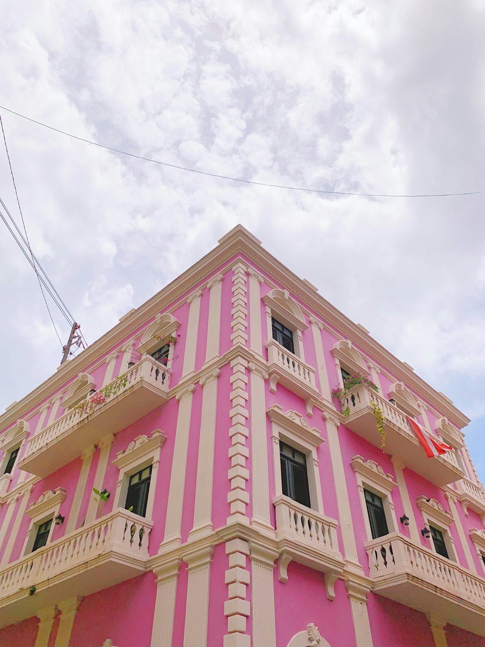 um edifício rosa com um telhado branco