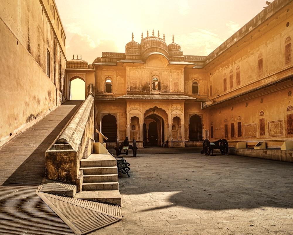 a courtyard with buildings and people with Nahargarh Fort in the background