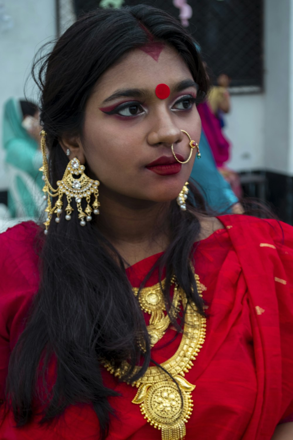 a woman with a red dress and gold jewelry