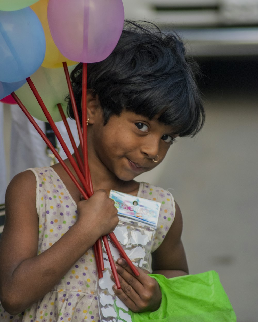 a young girl holding a book and a balloon