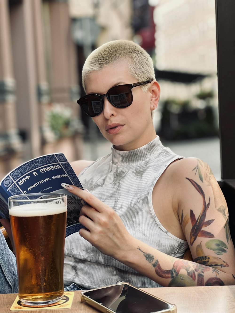 a person wearing sunglasses and sitting at a table with a glass of beer