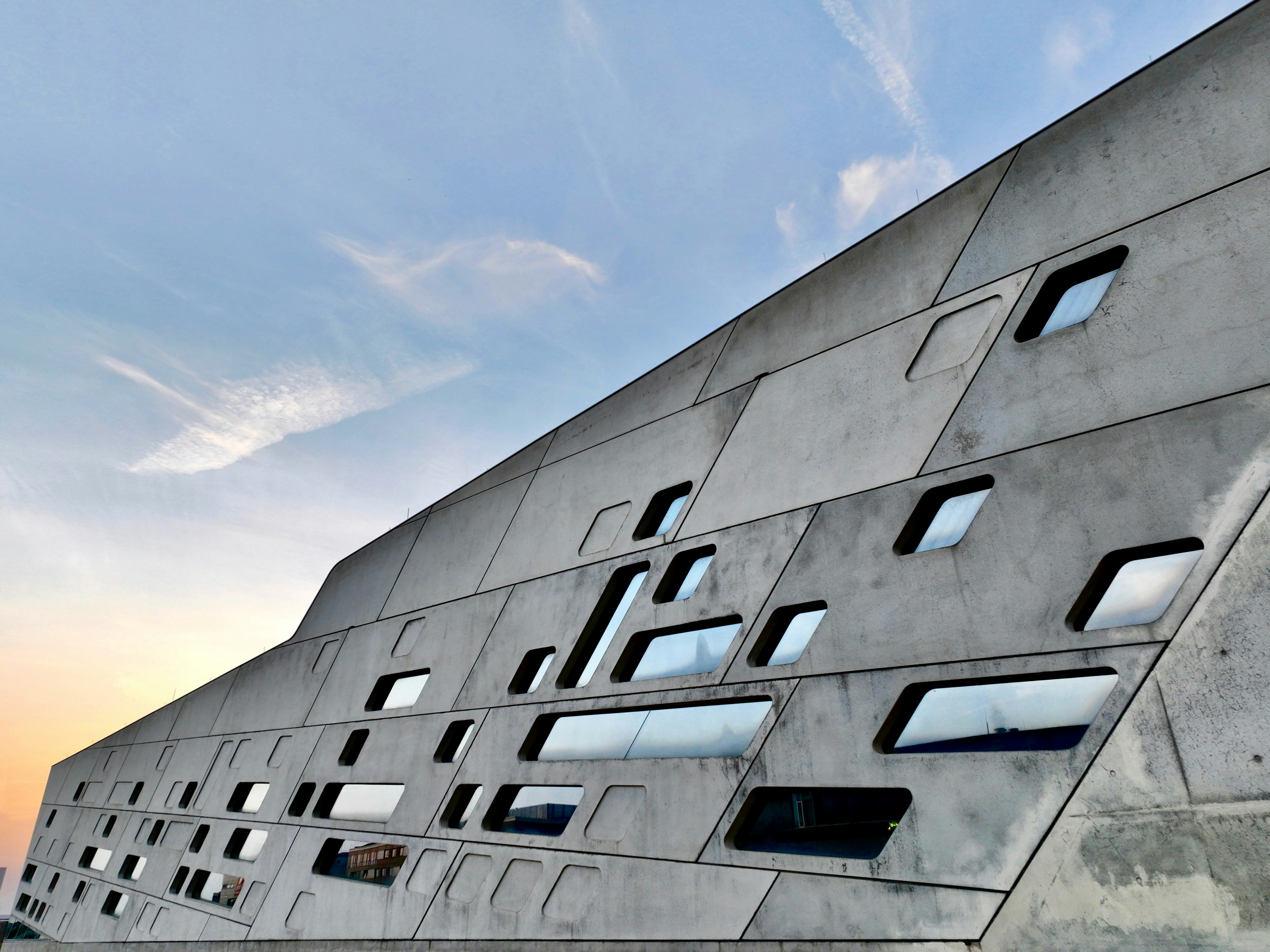 Modern concrete building with geometric windows against sky