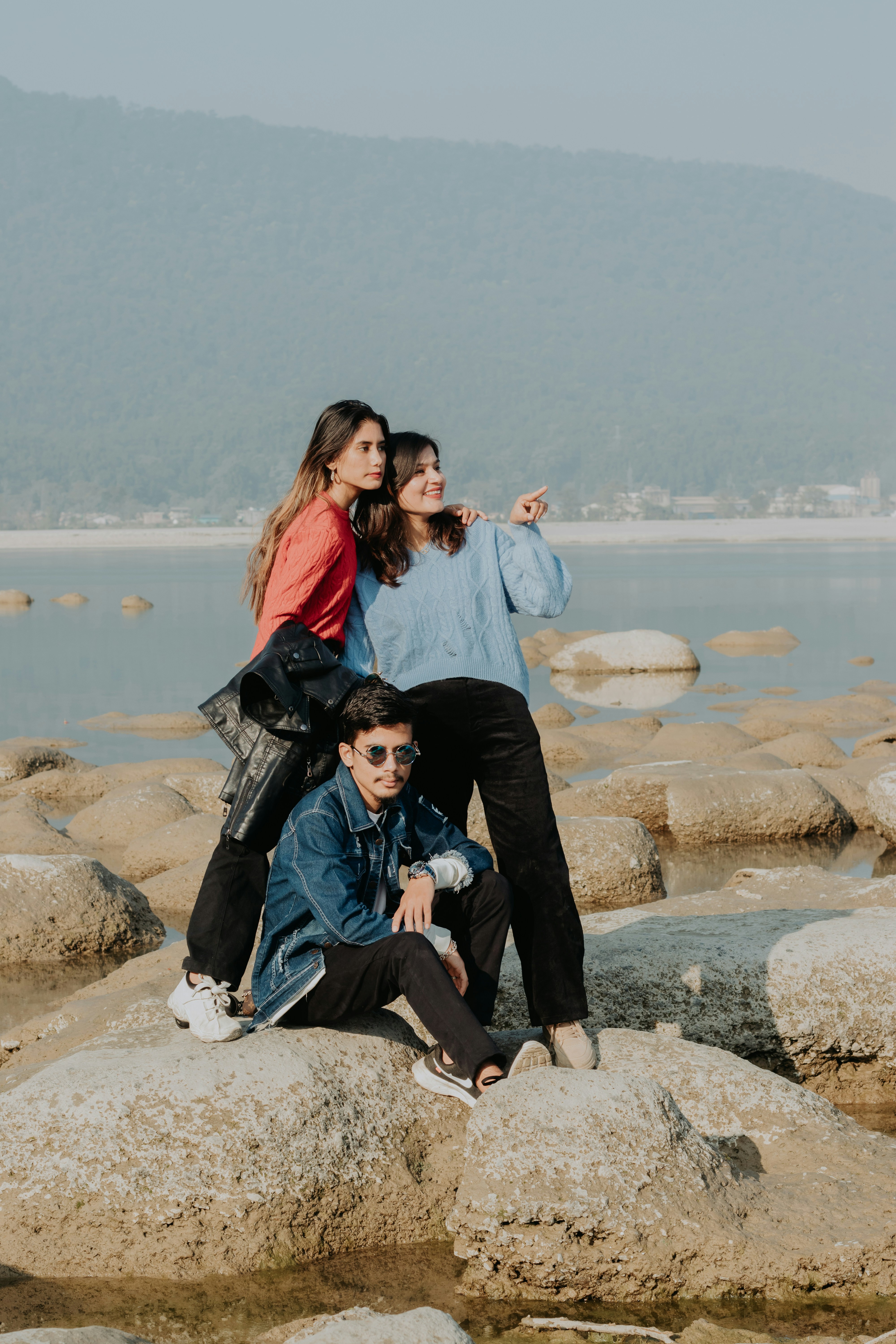 A group of people posing for a photo on a rocky beach photo – Free ...