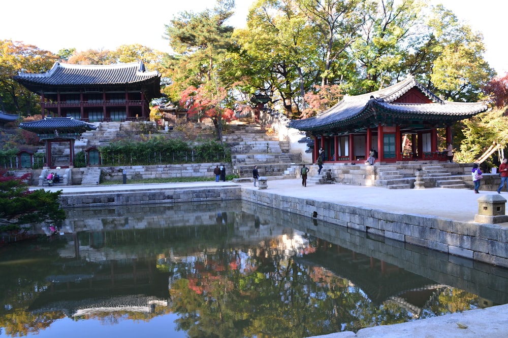 a pond with a building and trees around it