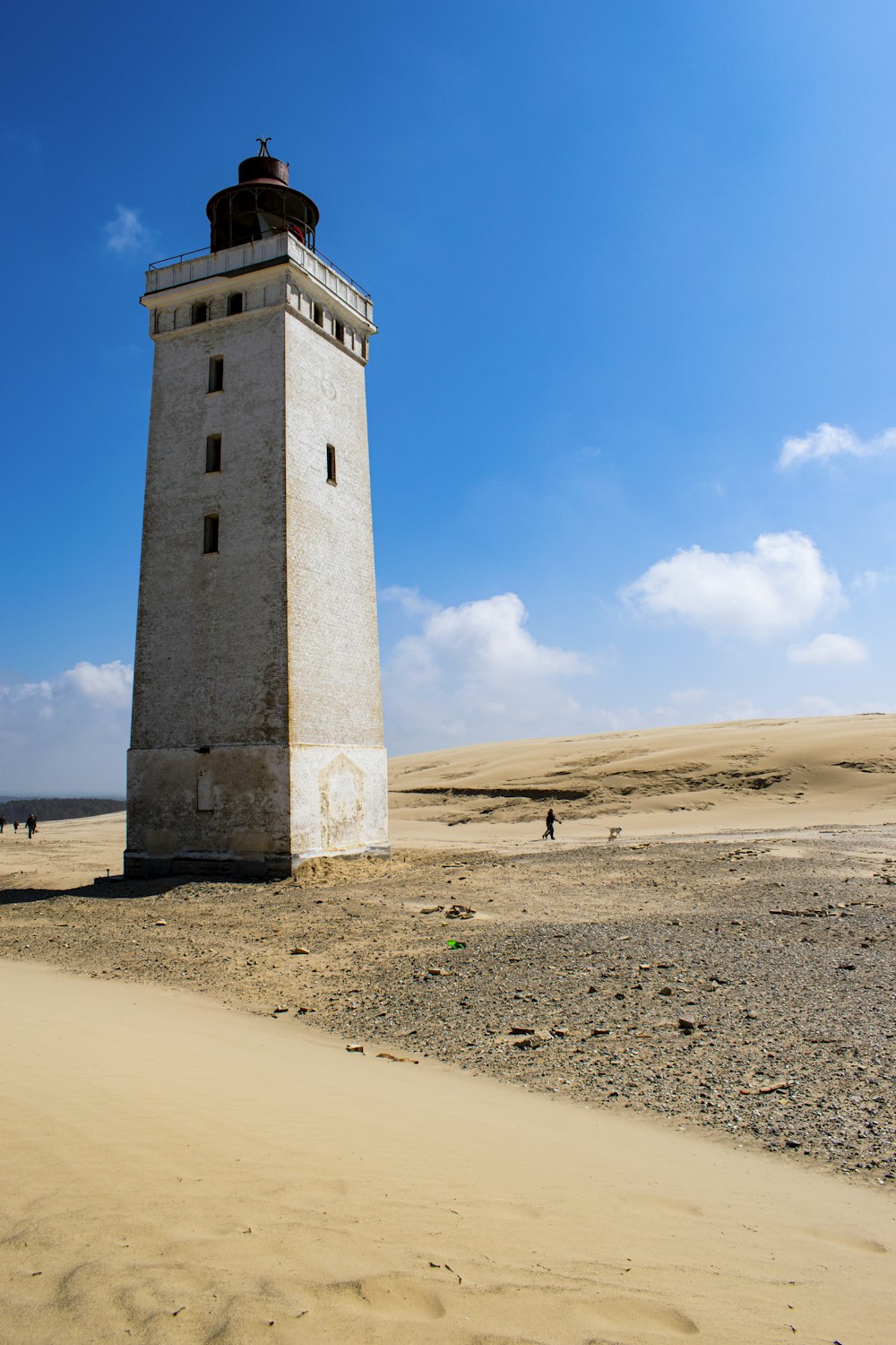 a lighthouse in the middle of a sandy area