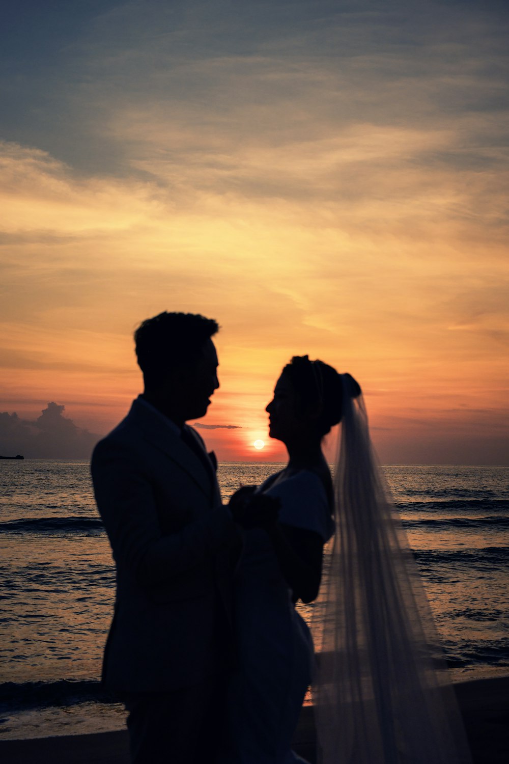 Un uomo e una donna che si baciano su una spiaggia al tramonto