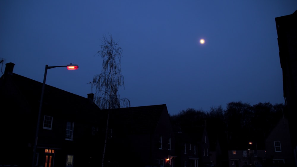 a moon in the sky over houses