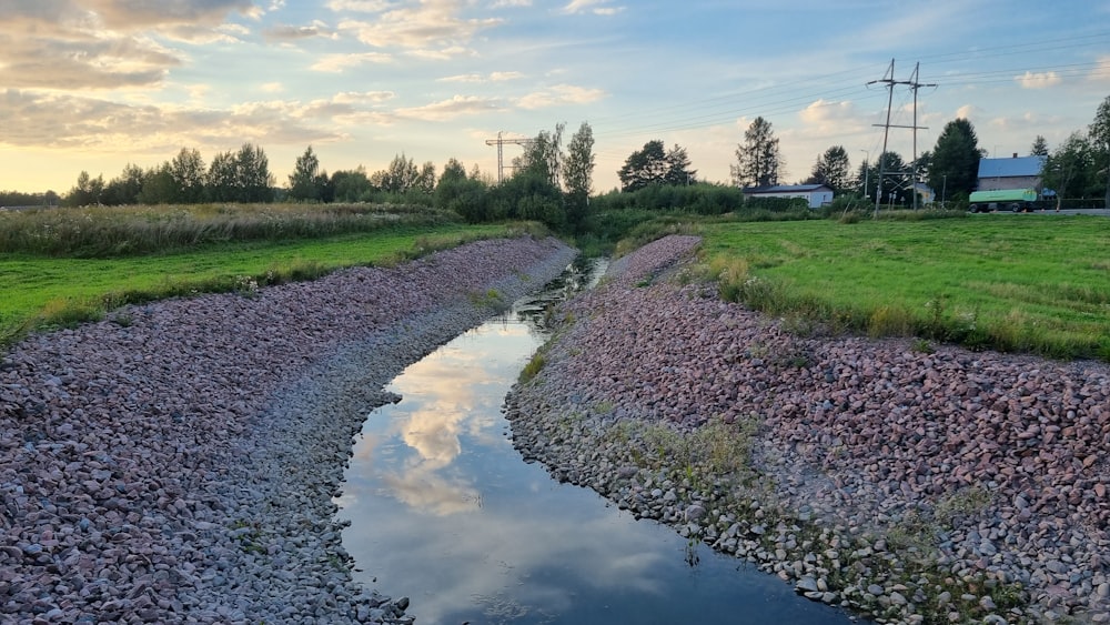 a muddy road with a puddle on the side