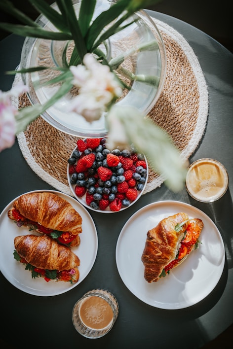 A cozy brunch table set with plates of fresh pastries and colorful smoothies.