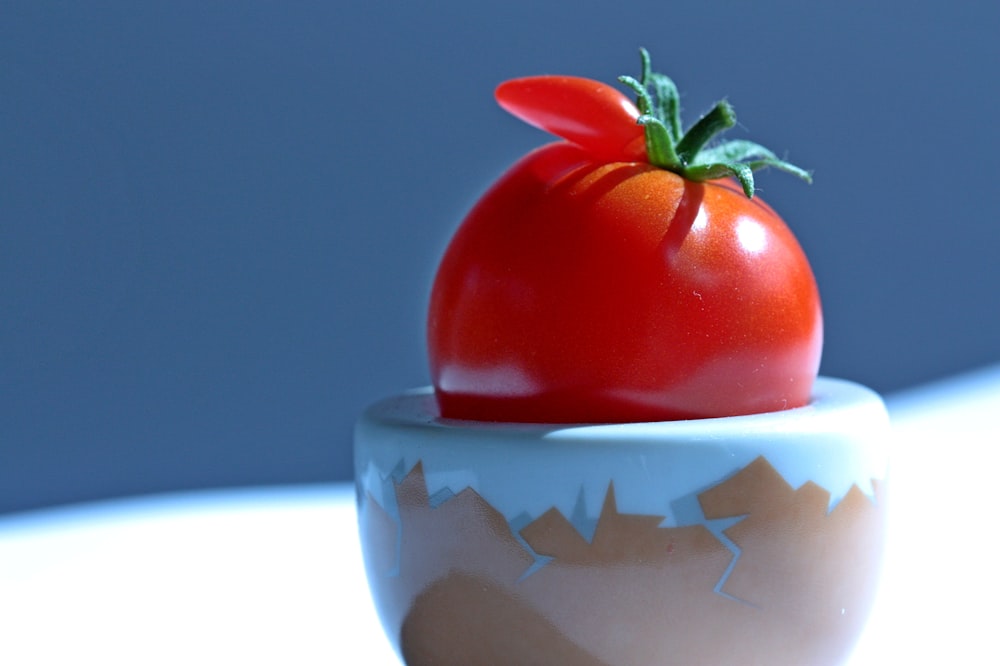 a tomato in a white cup