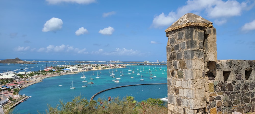 a stone wall with a body of water and boats in it