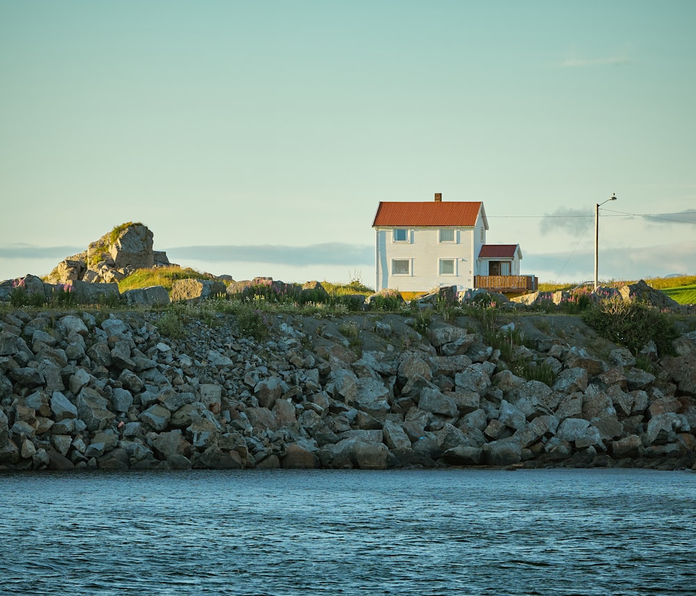 a house on a rocky hill by the water