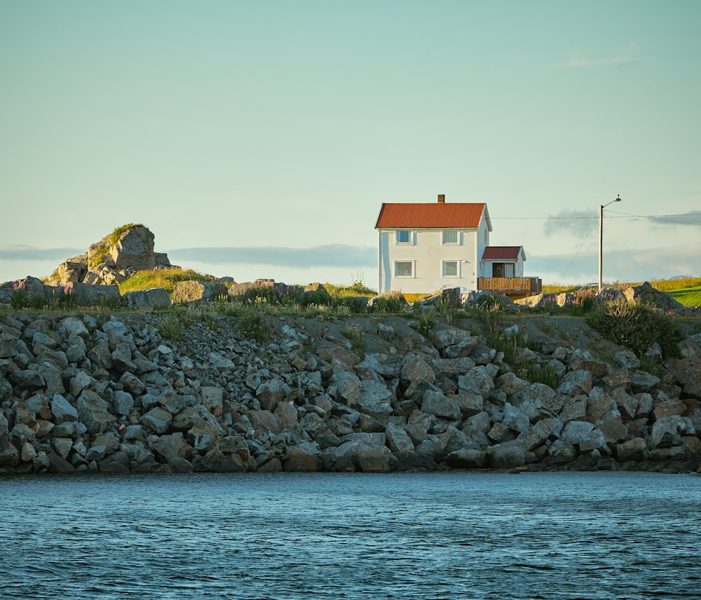 Una casa en una colina rocosa junto al agua