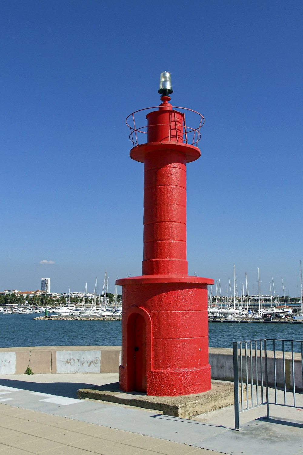 a red light house by the water