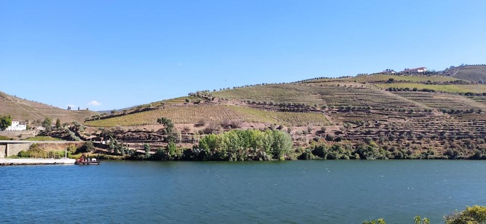 a body of water with a hill in the background