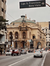 a street sign in front of a building with a dome roof