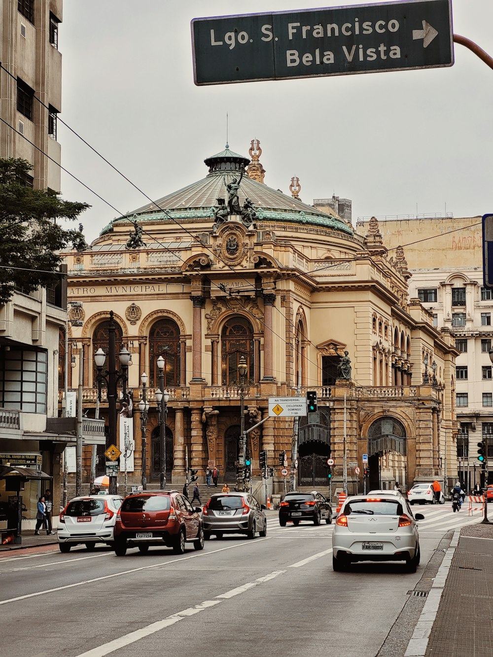 a street sign in front of a building with a dome roof