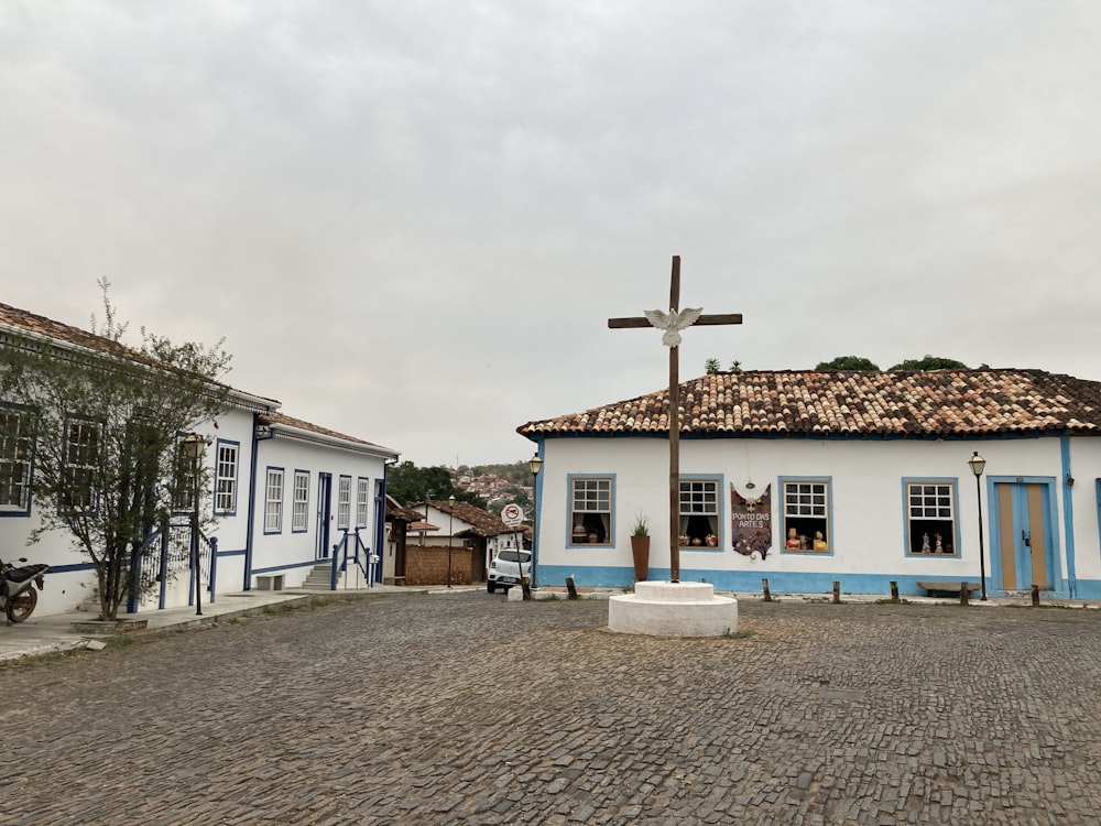 a cross on a pole in front of a building