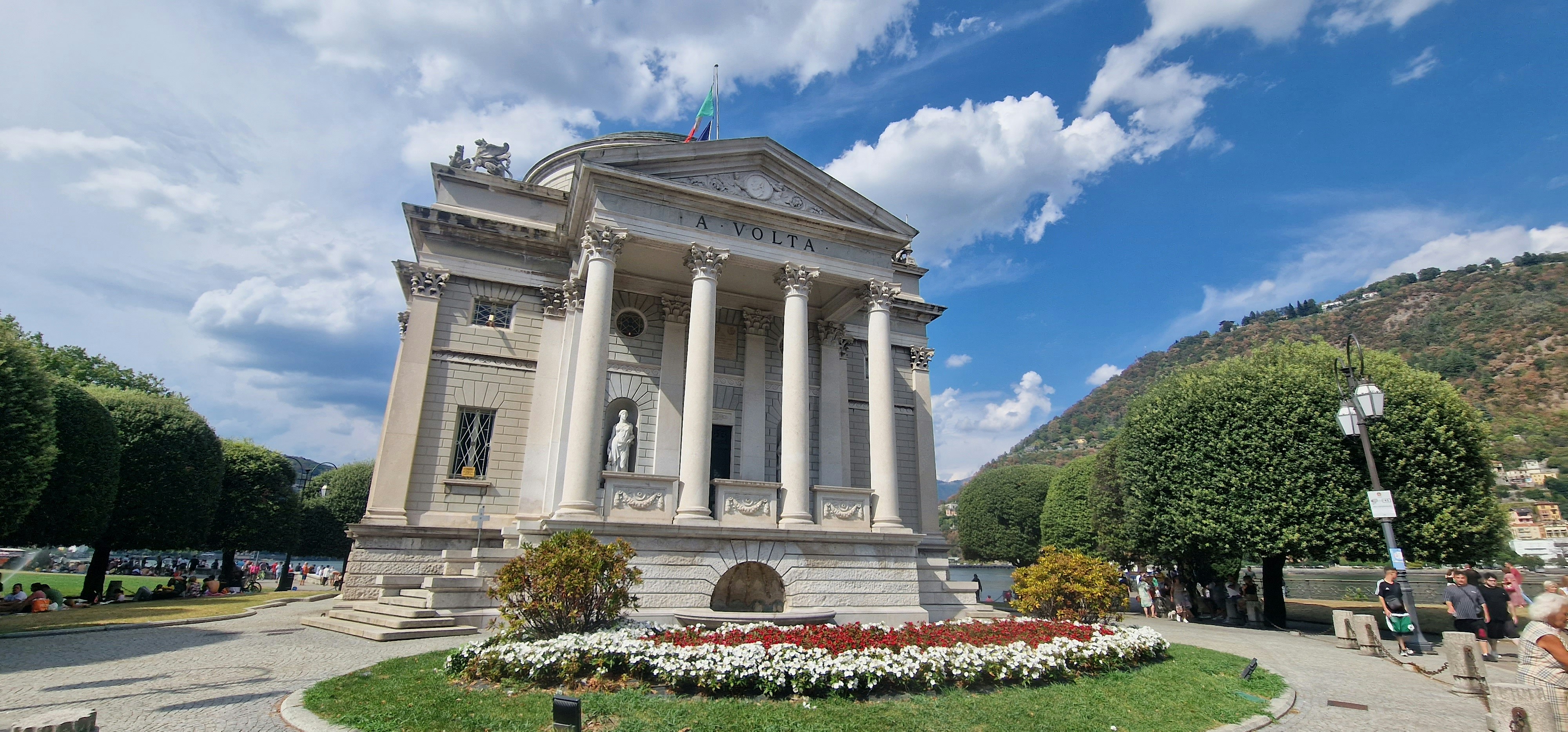 a white building with columns and a statue in front of it