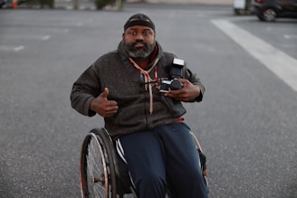 a man in a wheelchair pointing a camera
