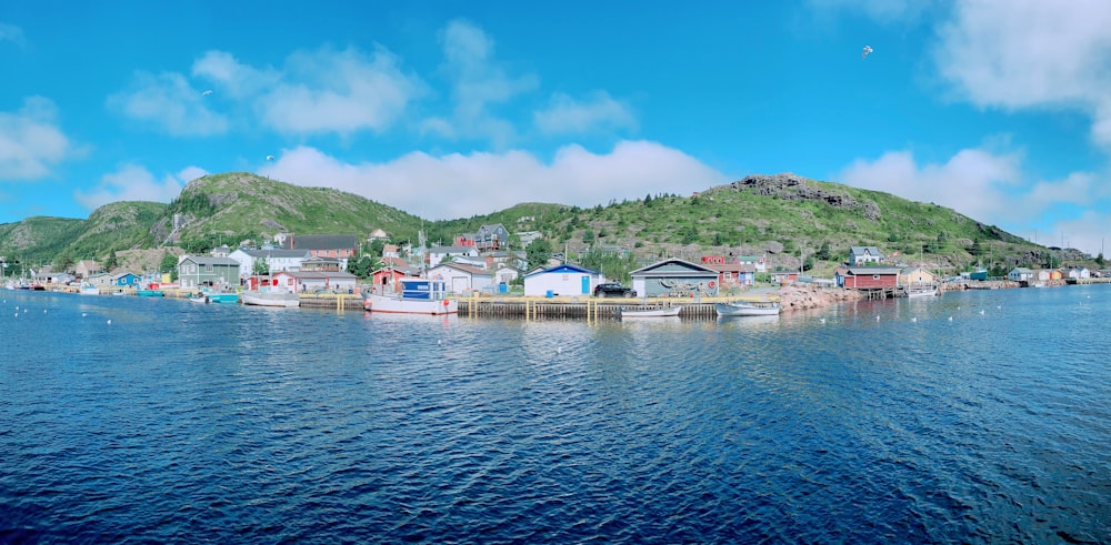 a body of water with buildings and hills in the background