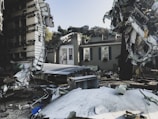 Collapsed building debris scattered across a neighborhood street.