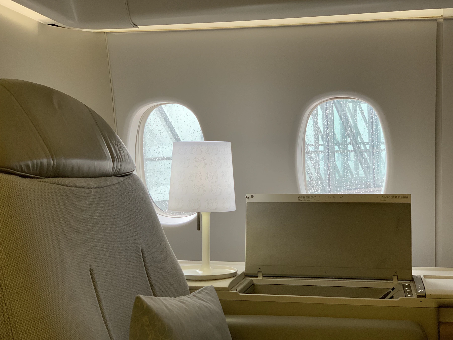 Low lamps and deep chairs in a dim lounge with rounded windows