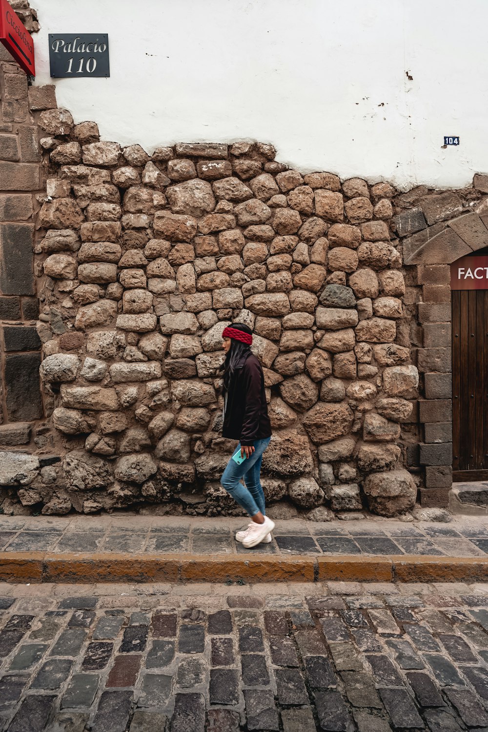 a person standing in front of a stone wall