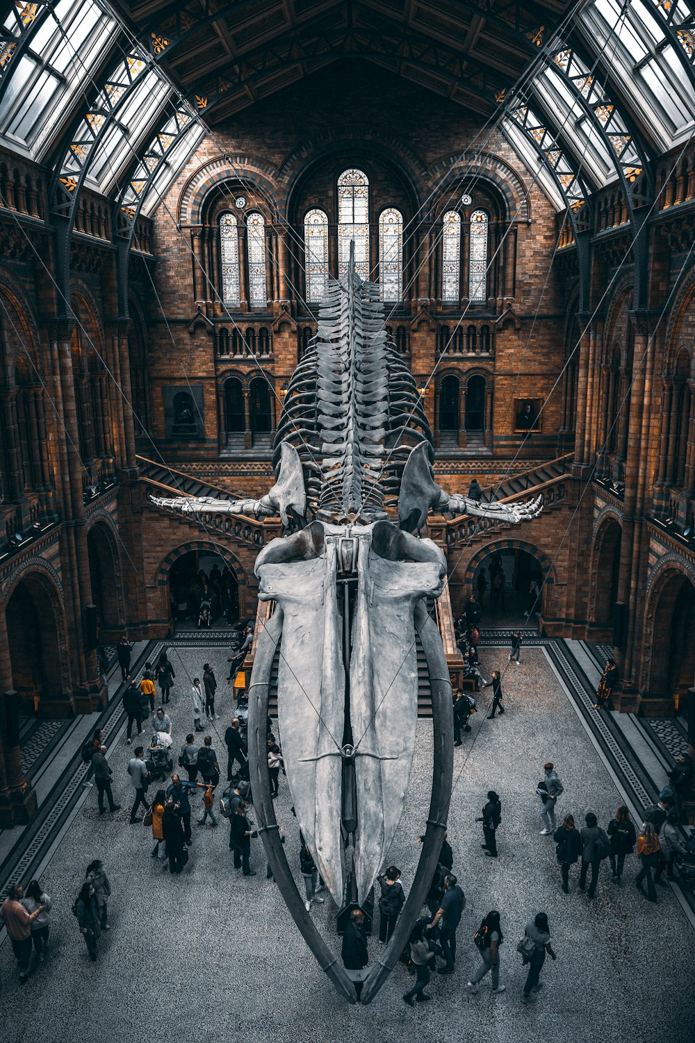 a large stone statue in a large building with people walking around