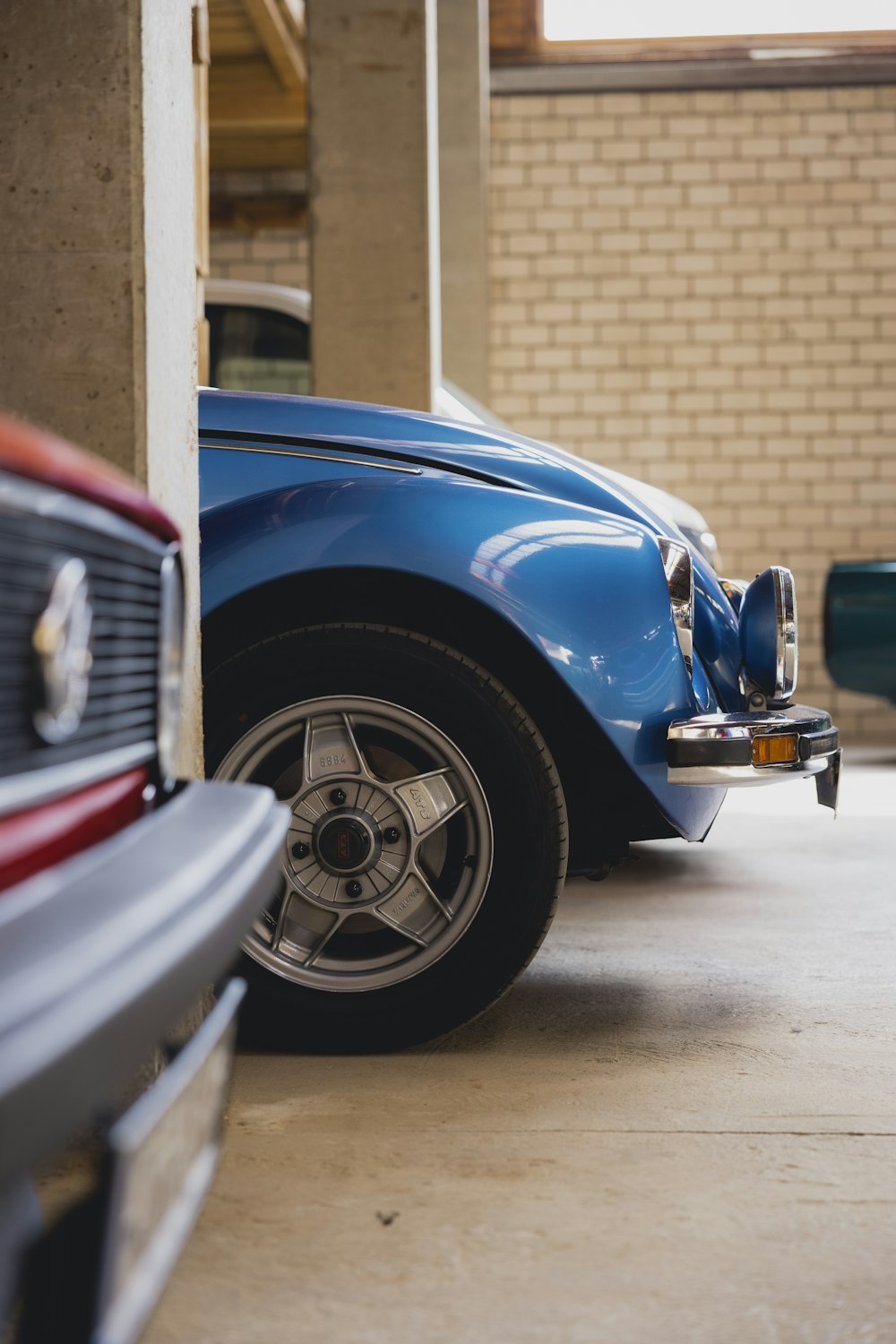 a blue car parked next to a white car