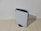 A sleek, modern gaming console stands vertically on a light-colored tiled floor. Featuring a distinctive white and black design, the console has a curved, futuristic appearance with the PlayStation logo visible on the front panel.