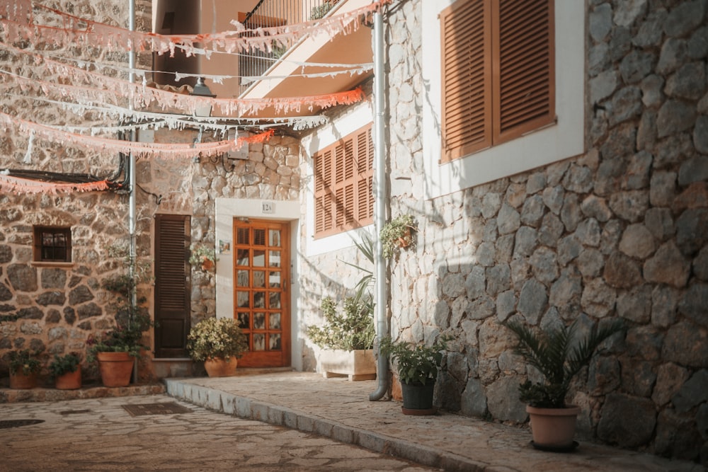 a stone building with a stone wall and plants