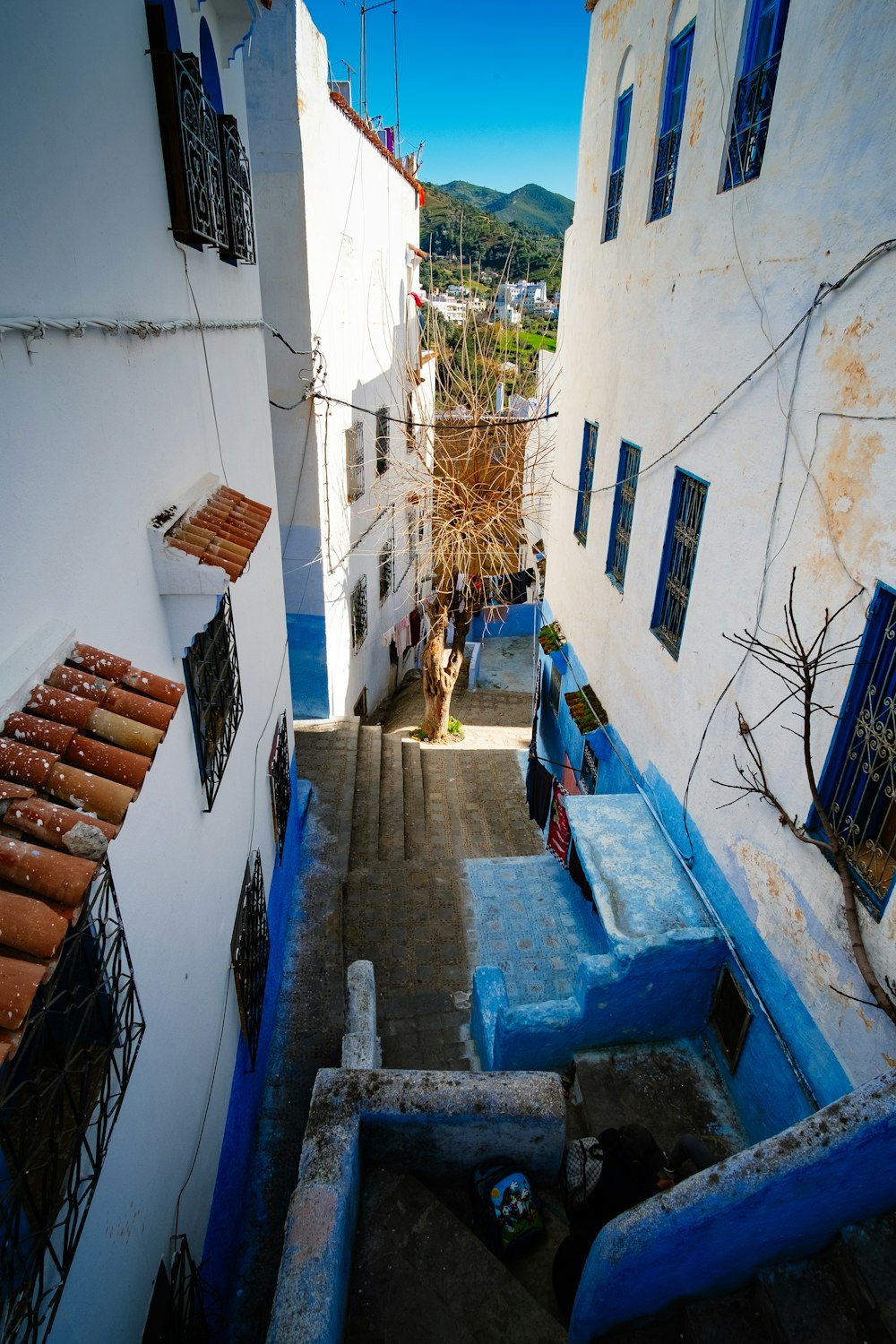 a narrow alley between white buildings