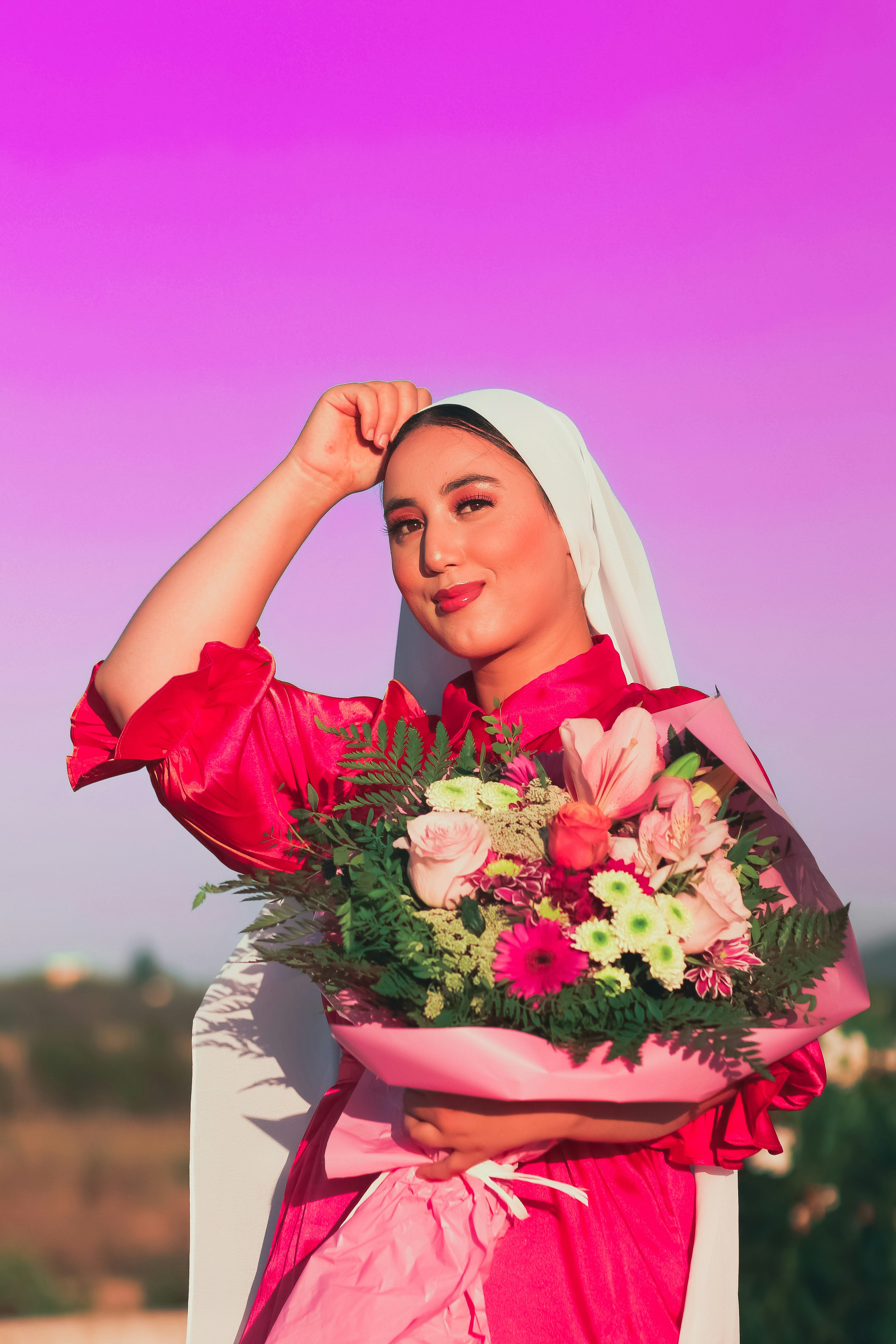 Seorang wanita bergaun merah memegang buket bunga