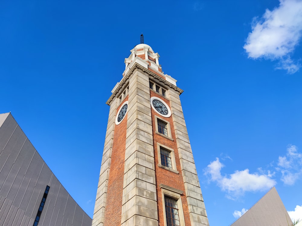 a clock tower with a weather vane with Clock Tower, Hong Kong in the background