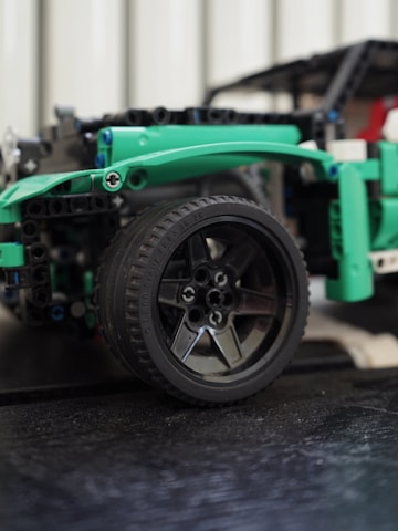 Close-up of hands adjusting the tires on a small RC racing car.