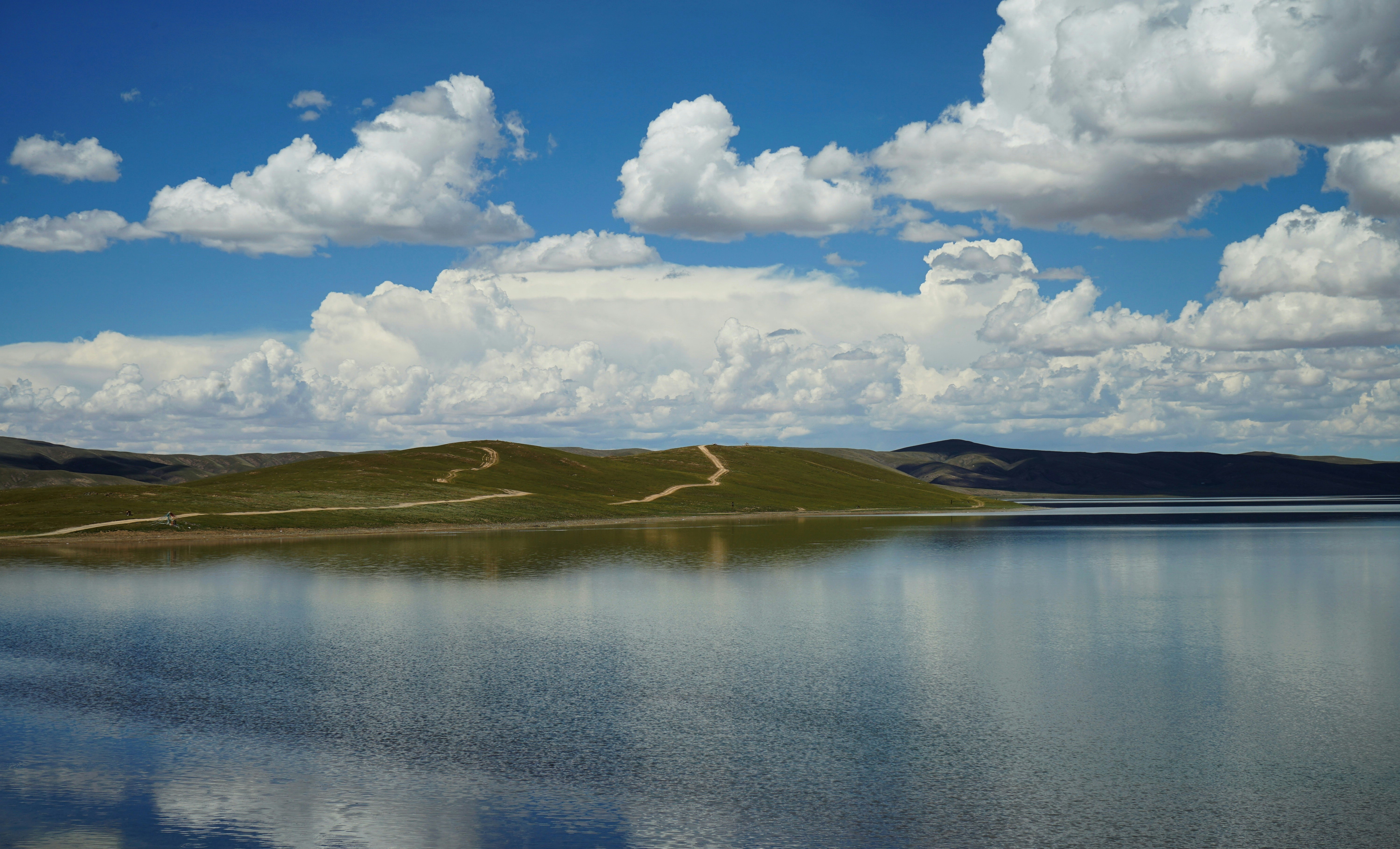 a body of water with hills in the background