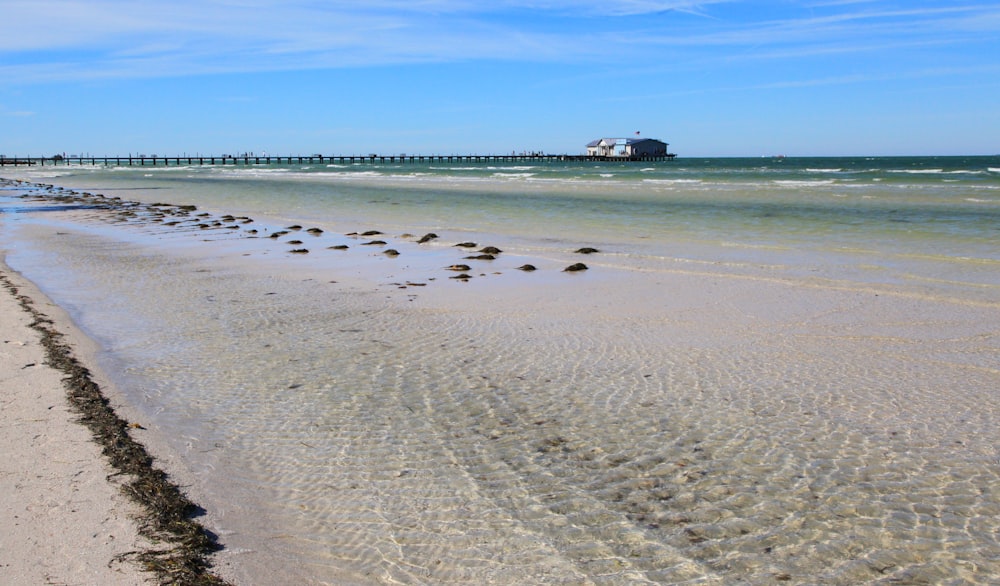 a beach with rocks and a pier