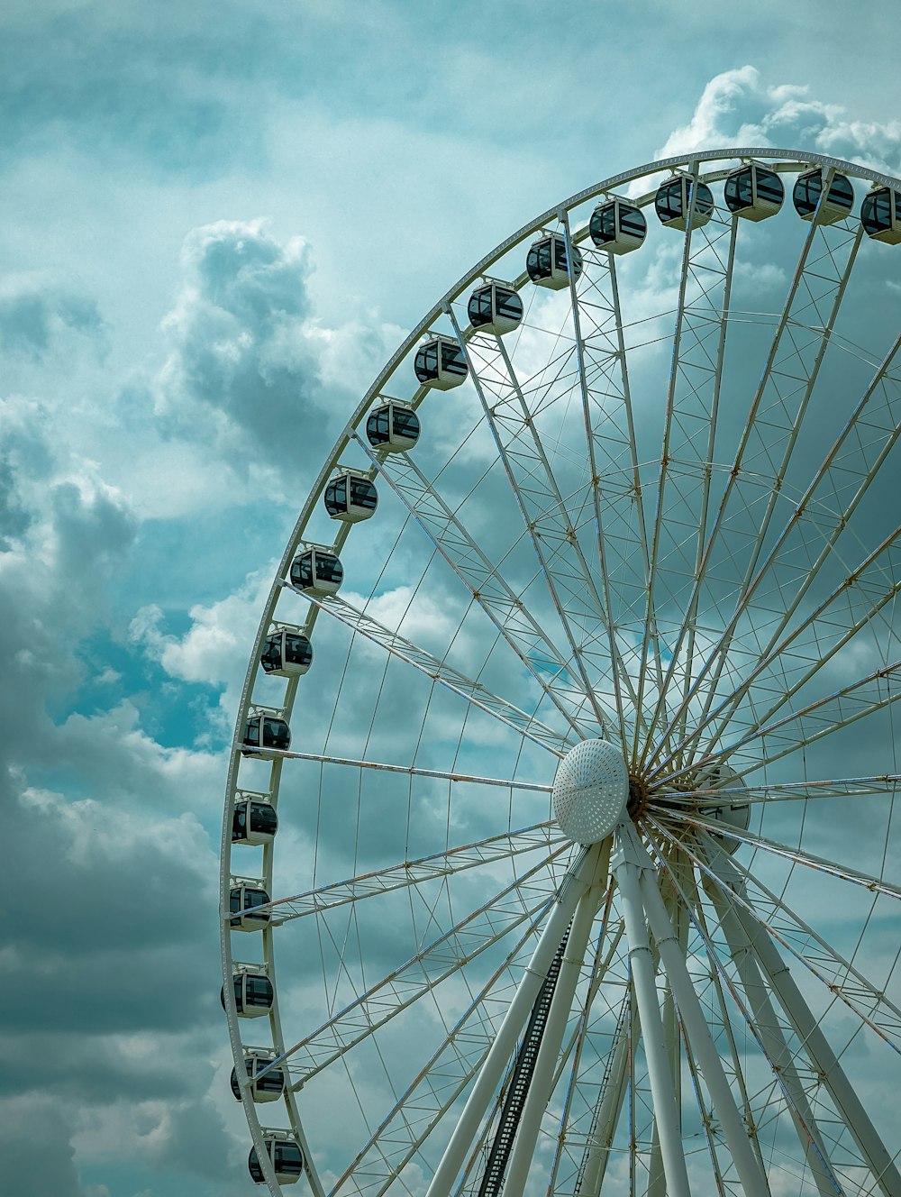 uma roda gigante com nuvens no fundo