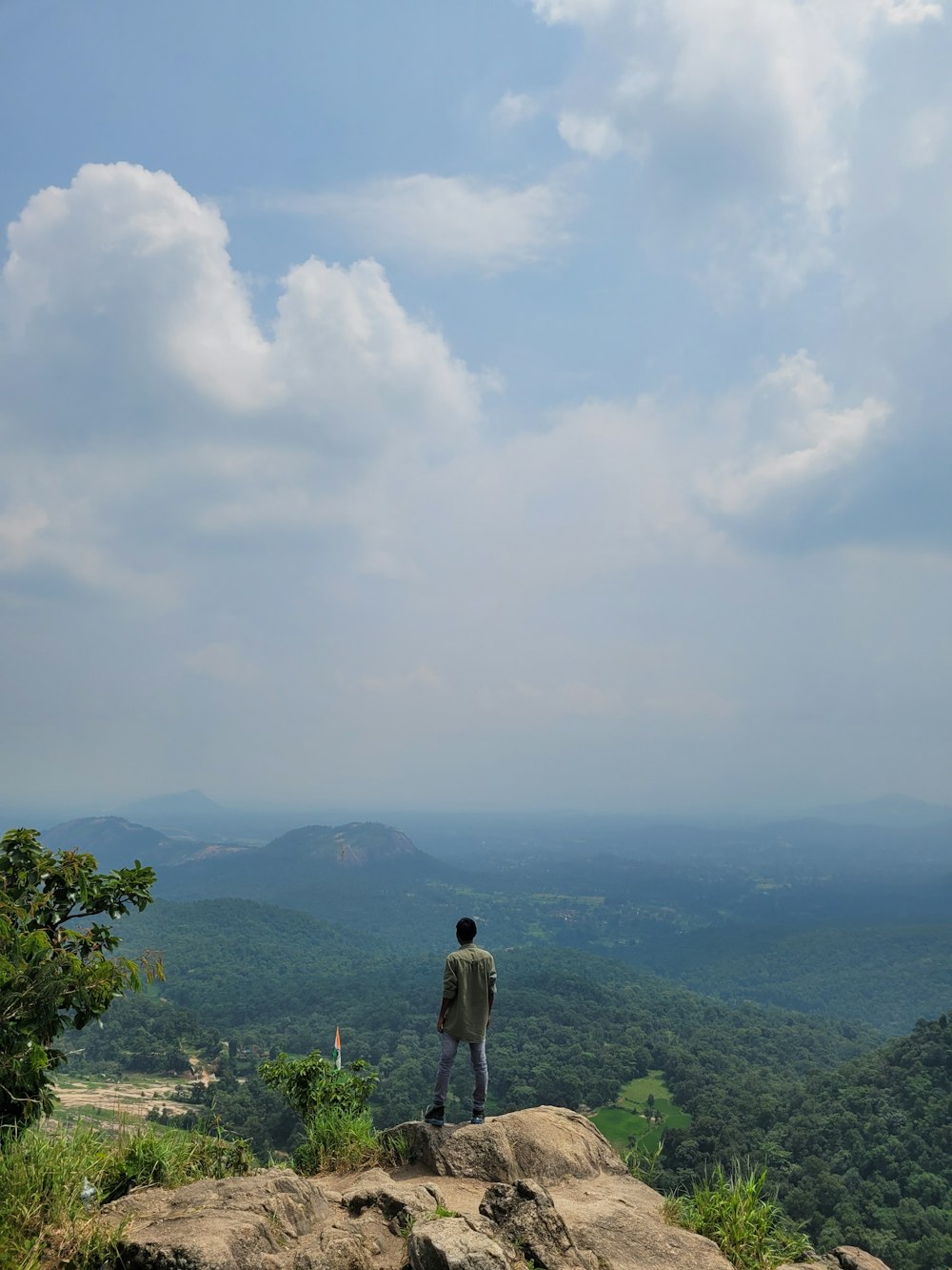 a person standing on a rock overlooking a valley