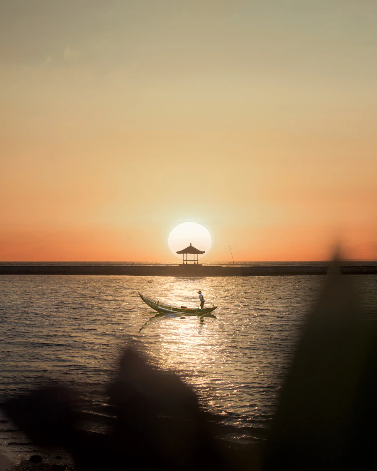 Peaceful sunrise bicycle boardwalk and calm barrier reef shallows in Sanur