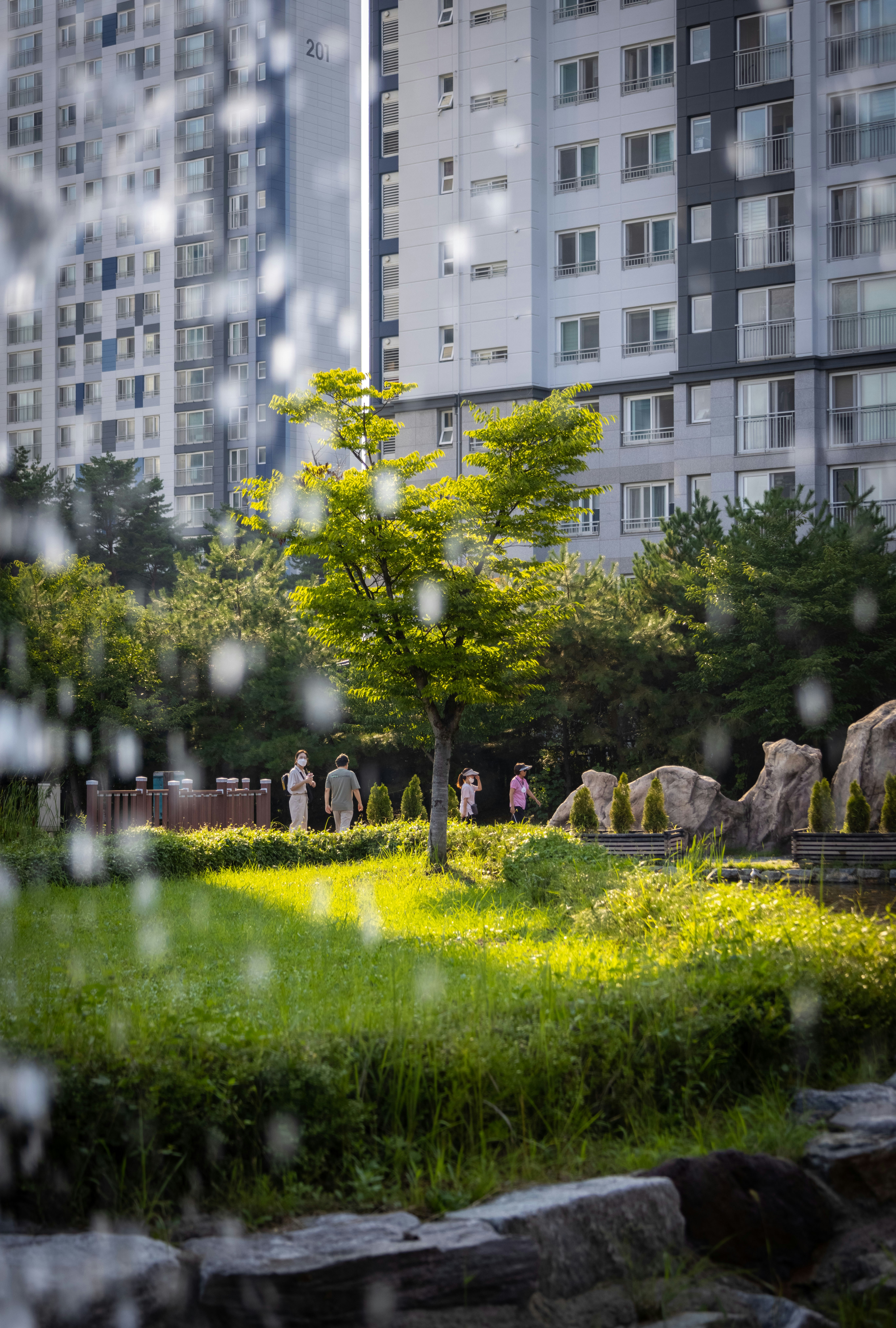 un groupe de personnes se promenant dans un parc devant un bâtiment