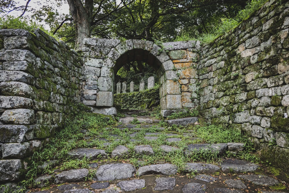 a stone archway with a stone wall