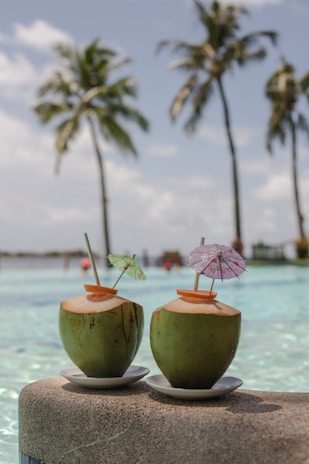 a couple of coconuts with umbrellas on a beach