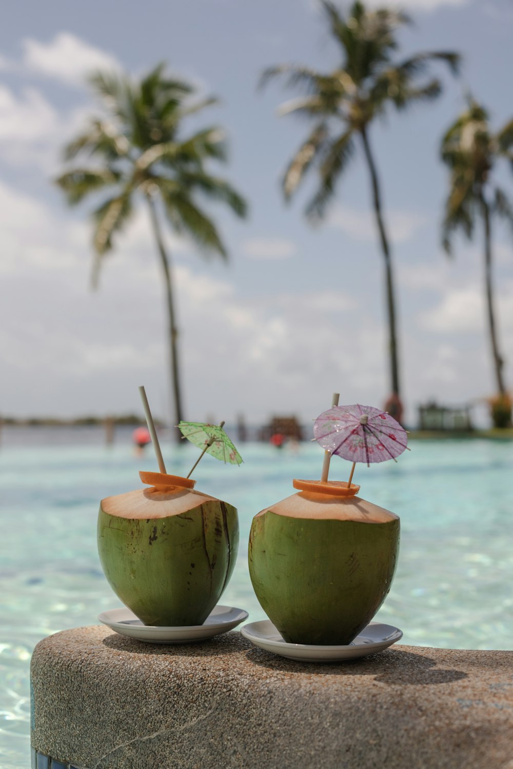 a couple of coconuts with umbrellas on a beach