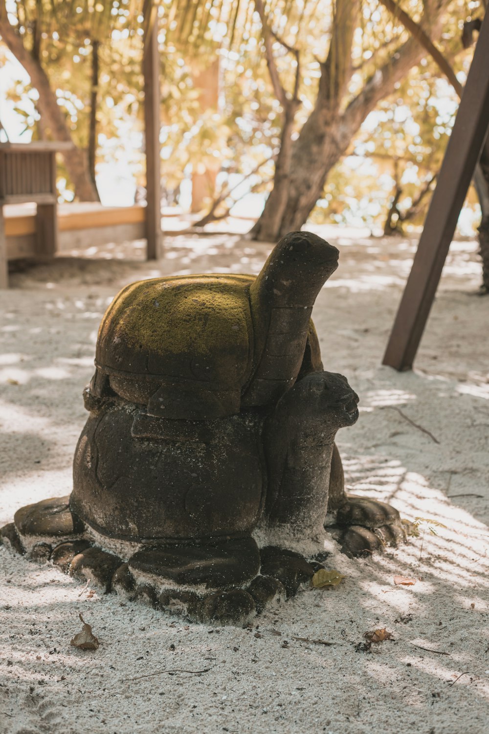 a statue of a person sitting on a rock in a park