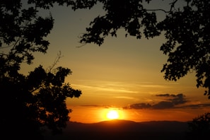 A vibrant sunset casting warm colors over the rolling hills and forests of the Nahuelbuta park.